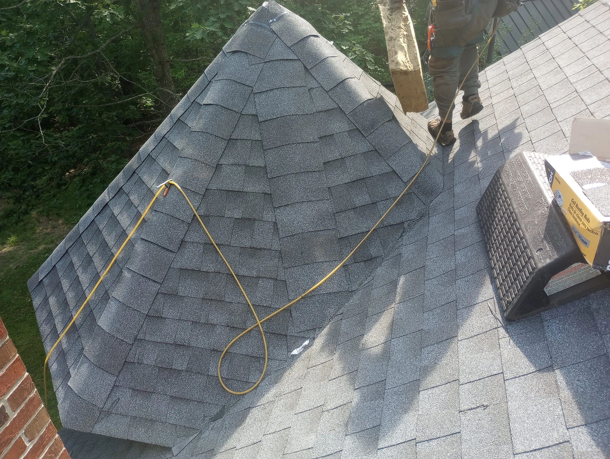 Expert roofing contractors install shingles on a conical roof. 